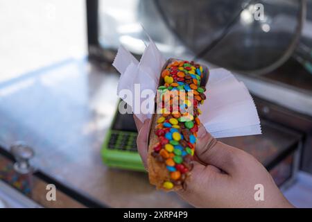 Nahaufnahme von Churros mit Schokoladencreme und Konfetti-Topping. Stockfoto