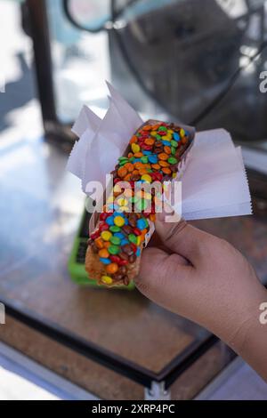 Nahaufnahme von Churros mit Schokoladencreme und Konfetti-Topping vertikal. Stockfoto