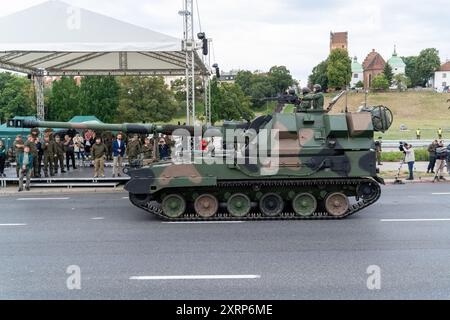 Warschau, Polen. August 2024. Krab kommt während der Generalprobe vorbei, während ein Soldat aus der Luke grüßt, während das Fahrzeug die Paraderoute passiert. Der Minister für nationale Verteidigung der Republik Polen Wladyslaw Kosiniak-Kamysz hielt nach der Probe der bevorstehenden Militärparade eine Pressekonferenz ab, an der mehr als 2.500 Soldaten aus allen Zweigen der polnischen Streitkräfte teilnehmen werden. Quelle: SOPA Images Limited/Alamy Live News Stockfoto