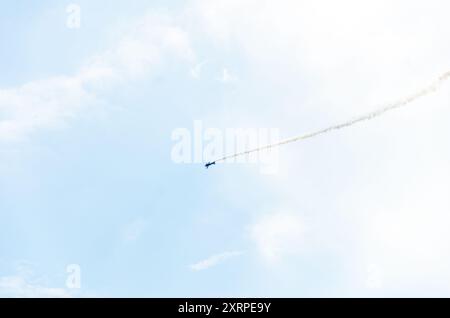 Ein einzelnes Flugzeug, das Kunstflug durchführt und Rauchspuren hinterlässt Stockfoto