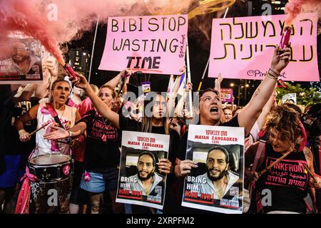 Tel Aviv, Israel. August 2024. Natali Zangauker, Schwester der israelischen Geisel Matan Zangauker, und ihr Cousin halten während der Kundgebung Plakate mit Matanís-Foto. Tausende Israelis demonstrierten mit den Familien der Geiseln gegen Premierminister Benjamin Netanjahu und forderten einen sofortigen Geiselvertrag und Waffenstillstand - während Israel auf den Angriff der Iraner und der Hisbollah wartet. Quelle: SOPA Images Limited/Alamy Live News Stockfoto