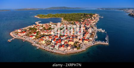 Krapanj, Kroatien - Panoramablick auf die Insel Krapanj (Otok Krapanj), die kleinste bewohnte Insel in Kroatien. Yachten, rote Dächer und Clear bl Stockfoto