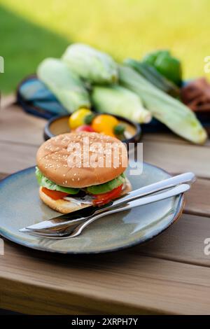 Nahaufnahme des Tellers mit hausgemachtem gegrilltem Hamburger und Besteck. Stockfoto