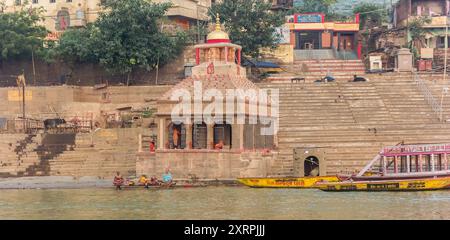 Panorama eines Tempels und Boote am Scindia Ghat in Varanasi, Indien Stockfoto