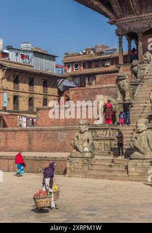 Eine alte Frau, die am Nyatapola-Tempel auf dem Durbar-Platz in Bhaktapur, Nepal, vorbeiläuft Stockfoto