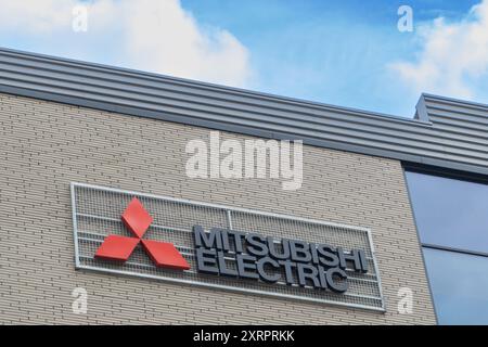 Posen, Polen. 9. August 2024: Nahaufnahme des Mitsubishi Electric Logos auf einem modernen Gebäude mit einer Backsteinfassade. Stockfoto