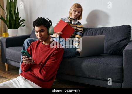 Ein glückliches multikulturelles Paar entspannt sich in ihrer modernen Wohnung und verbringt gute Zeit miteinander. Stockfoto