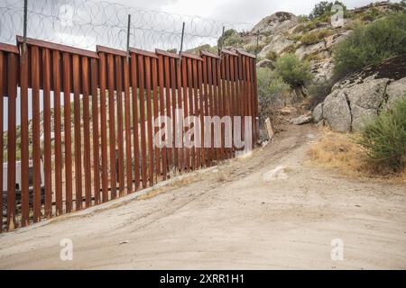 Jacumba Hot Springs, Usa. August 2024. Neben der Grenzmauer in Jacumba Hot Springs ist eine Lücke zu sehen. Die Gegend in Jacumba Hot Springs in Kalifornien ist einer der beliebtesten Orte, an denen Migranten die Grenze von Mexiko in die Vereinigten Staaten überqueren. Obwohl auf beiden Seiten viele Offiziere patrouillieren, kommen jeden Tag Hunderte von Migranten in die Vereinigten Staaten. (Foto: Michael Ho Wai Lee/SOPA Images/SIPA USA) Credit: SIPA USA/Alamy Live News Stockfoto