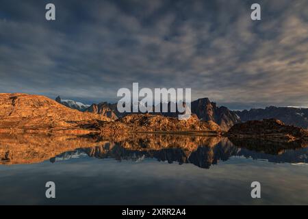 Reflexion der steilen Berge in einem abgelegenen Fjord im Abendlicht, atmosphärisch, Scoresby Sund, Ostgrönland, Grönland Stockfoto