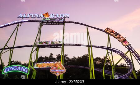 Herne, NRW, Deutschland. August 2024. Sonnenuntergang über der Alpina Bahn Achterbahn. Am letzten Tag des Cranger Kirmes, Deutschlands zweitgrößtem Jahrmarkt, im Herzen des Ruhrgebiets, genießen Zehntausende die Fahrgeschäfte und Attraktionen bei herrlicher, heißer Sonne bei Temperaturen um 30 Grad. Die Messe hat in Herne Crange eine lange Tradition, die bis zu einem mittelalterlichen Markt zurückreicht und jährlich etwa 4 Millionen Besucher anzieht. Quelle: Imageplotter/Alamy Live News Stockfoto