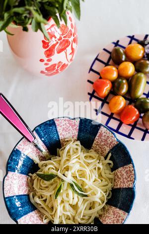 basilikum, Mini-Tomaten und große Schüssel frische Nudeln Stockfoto