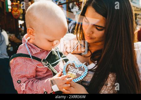 Mama und Baby auf dem Oktoberfest München halten Keksherz Stockfoto