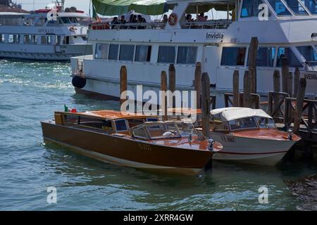 Farbenfrohe Boote legten im Blauen Wasser Venedigs an Stockfoto