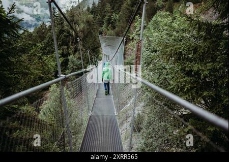 Zwei Jungs laufen auf einer Hängebrücke im regnerischen Wallis, Schweiz Stockfoto