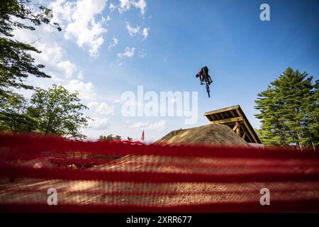 Ein Mountainbiker startet in einem Bikepark einen Sprung Stockfoto