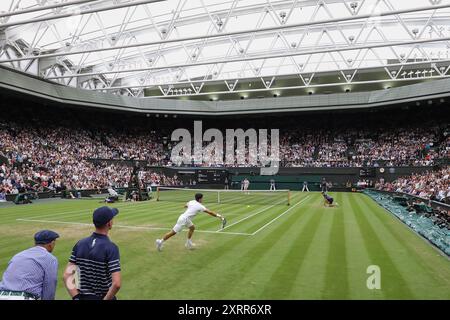 Der spanische Tennisspieler Carlos Alcaraz gegen Ugo Humbert (Hintergrund) bei den Wimbledon Championships 2024 in London, England. Stockfoto