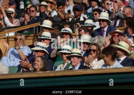 Zuschauer in der Royal Box tragen Hüte in der Sonne auf dem Mittelfeld bei den Wimbledon Championships 2024 in London, England. Stockfoto