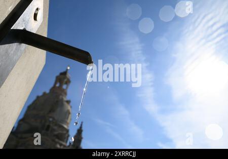 Dresden, Deutschland. August 2024. Trinkwasser fließt aus einem Wasserhahn aus einem öffentlichen Trinkwasserbrunnen auf dem Neumarkt vor der Fraunkirche bei Sonnenschein. Robert Michael/dpa/Alamy Live News Stockfoto