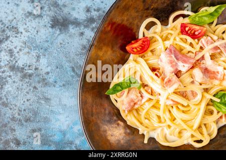 Klassische Pasta Carbonara in einer Keramikplatte, herzhaftes italienisches Gericht mit Spaghetti, Ei, gebratenem Speck, gekrönt mit geriebenem Parmesan-Käse und schwarzem pe Stockfoto