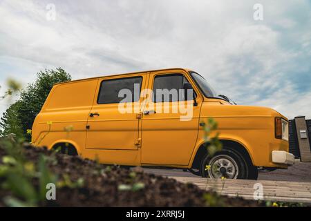 Ein gelber Van, der auf einer asphaltierten Straße geparkt ist Stockfoto