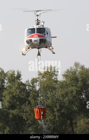 REDDING CALIFORNIA – 10. AUGUST 2024 – Ein CALFIRE Bell UH-1 Hubschrauber hebt mit Wasser vom Mary Lake ab, um das untere Feuer in der Nähe von Lower Springs zu bekämpfen Stockfoto