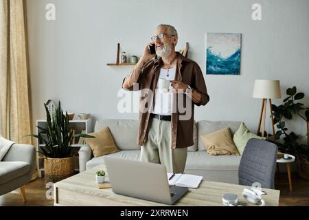 Ein reifer schwuler Mann mit Tattoos und grauen Haaren lächelt, während er von zu Hause aus arbeitet. Stockfoto