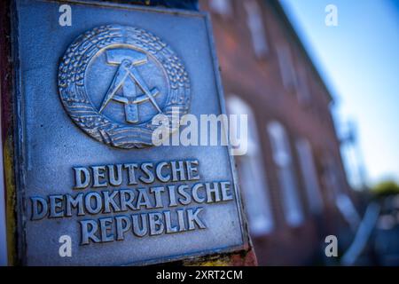 Schlagsdorf, Deutschland. August 2024. Eine DDR-Grenzsäule aus der ehemaligen innerdeutschen Grenze ist vor dem Grenzhus Schlagsdorf zu sehen. Zahlreiche Veranstaltungen erinnern an den Tag des Mauerbaus und der Schließung der innerdeutschen Grenze am 13. August 1961. Historiker schätzen, dass an der innerdeutschen Grenze rund 650 Menschen ums Leben kamen. Quelle: Jens Büttner/dpa/Alamy Live News Stockfoto