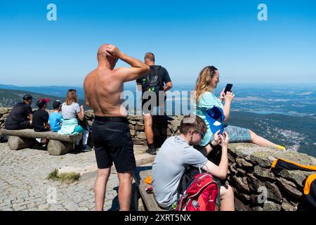 Aktive Menschen Alter Mann, eine Frau mittleren Alters mit einem Handy, und ein Junge, der an einem sonnigen Sommertag auf der Landschaft von Snezka Polen ruht Stockfoto