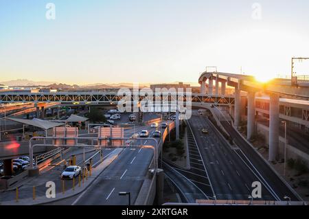 Erhöhter Überblick über den Abflugbereich des Flughafens Phoenix Sky Harbor Terminal 4, den Fahrzeugverkehr, die Eisenbahnbrücke des PHX Sky Train und die Halle Stockfoto