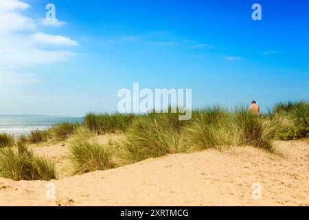 Eine Person sitzt in der Sonne auf einer Sanddüne. Stockfoto