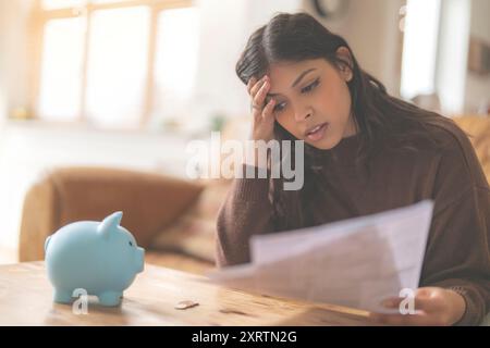Besorgte junge indianerin, die Briefe liest, Sparersparnis, Arbeitssteuer, die Energierechnung bezahlen, verwirrte Verwirrung Stockfoto