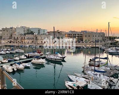 Mit Blick auf den Fischerhafen des wunderschönen Giovinazzo, Italien, voller Yachten an einem warmen Sommerabend Stockfoto