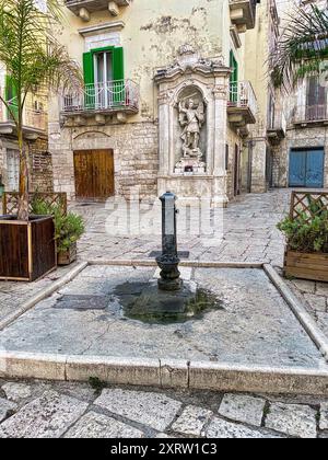 Öffentlicher Trinkwasserbrunnen in einem typisch italienischen Innenhof in Italien an einem heißen Sommertag Stockfoto