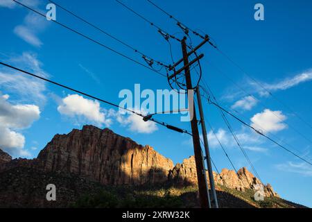 Blick auf die Bergrücken im Zion National Park, Utah, USA, mit Drähten, die an Telegrafenmasten hängen. Stockfoto