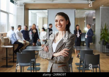 Porträt einer glücklichen positiven jungen Geschäftsfrau, die am Arbeitsplatz im Loft-Büro in der Kamera lächelt. Stockfoto