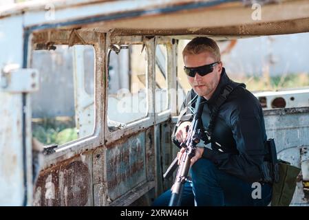 Ein Mann mit einem Maschinengewehr in der Hand macht eine militärische Ausbildung und lernt, auf den Schießstand zu schießen Stockfoto