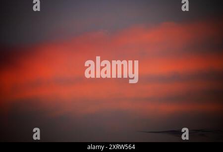 Die untergehende Sonne schafft ein abstraktes Pastellbild von Himmel und Wolken. Stockfoto
