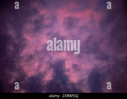Die untergehende Sonne schafft ein abstraktes Pastellbild von Himmel und Wolken. Stockfoto