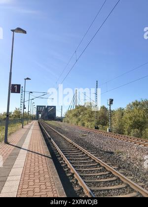 Ein Bahngleis mit einem Schild mit der Aufschrift 1. Der Himmel ist klar und hell. Die Bahngleise sind leer Stockfoto