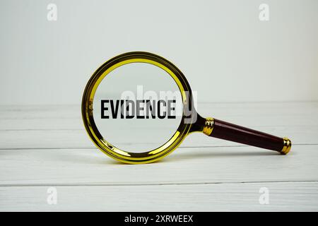Evidentext mit Lupe auf hölzernem Hintergrund Stockfoto