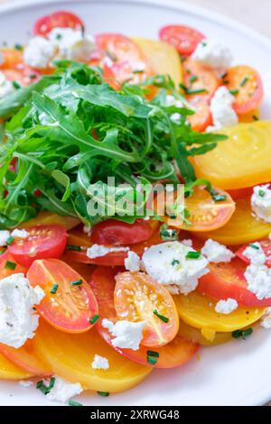 Frischer Tomaten- und Käsesalat mit Ornage und roten und gelben Tomaten, Weichkäse und Dressing. Stockfoto