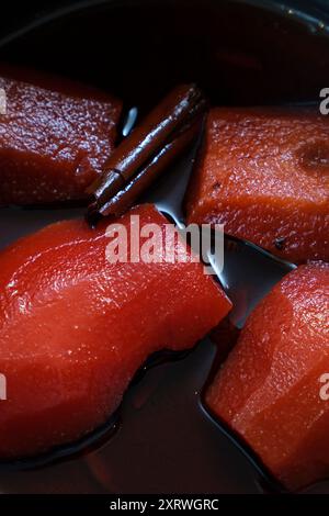 Nahaufnahme einer Pfanne mit gedünsteten Birnen in Rotweinsauce und Zimt. Stockfoto
