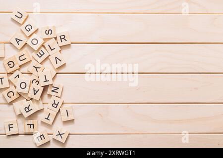 Ein Holzbrett mit einem Haufen Holzbuchstaben darauf. Die Buchstaben haben verschiedene Größen und Formen und sind überall auf dem Brett Stockfoto