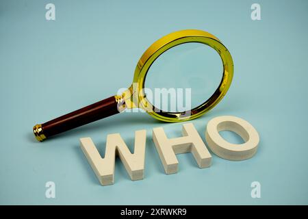 WER? Wort mit Lupe auf blauem Hintergrund Stockfoto