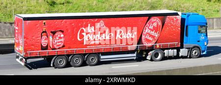 TSA blauer DAF-Lkw-Lkw-Lkw mit kleinem Anhänger mit seitlichem Vorhang, Werbung für La Goudale Rubis French Beer auf der Autobahn M25 in Großbritannien Stockfoto