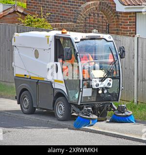 Straßenbreite Bucher mechanische Doppelbürsten-Kehrmaschine und Fahrer am Standort des Arbeitsdorfes, Fahrt entlang des Weges für Brentwood Council Essex England UK Stockfoto