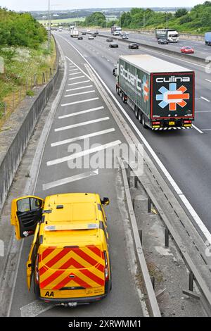 AA Pannenwagen parkt auf der Autobahn M25 hart Schulter ein Mechaniker, der an einem Pannenfahrzeug arbeitet, das unter der Straßenbrücke Essex England UK nicht zu sehen ist Stockfoto