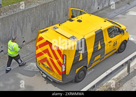 Gleicher Vorfall Alamy 2XRWMM1 AA Mechaniker geht zum Van, um Werkzeuge zu finden, die den Autofahrer in einem Panne unter der Autobahnbrücke Essex England UK unterstützen Stockfoto