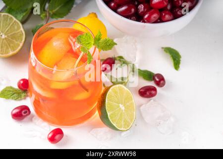 Kornelkirsche, Harthölzer essbare Beere Caipirinha, Limonade oder Sangria Getränk mit Eiswürfeln und Limettensaft, auf weißem Küchentisch Hintergrund Kopie sp Stockfoto