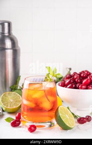 Kornelkirsche, Harthölzer essbare Beere Caipirinha, Limonade oder Sangria Getränk mit Eiswürfeln und Limettensaft, auf weißem Küchentisch Hintergrund Kopie sp Stockfoto